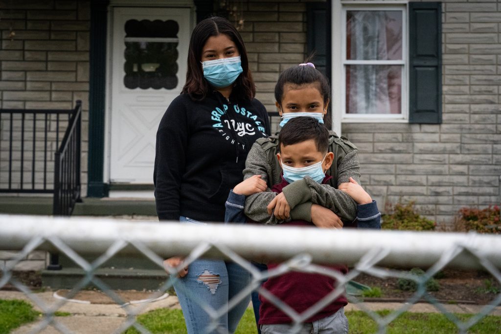 Cesia, 15, stands with her niece Belsis, 11, and nephew Frank, 7, outside their home in Baltimore.